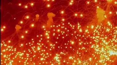 Bir akşam kutlaması sırasında parlak bir dizi havai fişek patlar. Her biri parlak kıvılcımlar saçarak karanlığı aydınlatır..