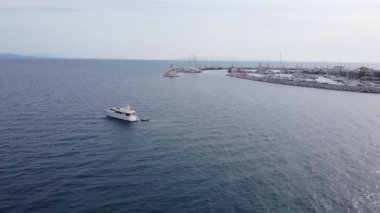 Parıldayan turkuaz okyanus sularına demir atmış lüks beyaz bir yatın sinematik hava aracı görüntüleri. Kaliteli zenginliğin özünü yansıtan kaliteli bir görsel, özel yaz tatilleri, ve nihai rahatlatıcı deniz yaşam tarzı..