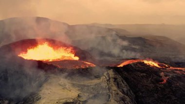 Erimiş Lavın volkanik patlaması Yoğun Isı ve Duman Gösteren Puslu Turuncu Gökyüzünün Altında Bir Dağdan Akıyor