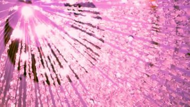 Soyut pembe ışık çizgileri ve kristal süslemelerin asılı olduğu parlak bir sahne. Görüntünün rüya gibi ve zarif bir havası var. Arka plan ya da şenlikli tasarımlar için mükemmel. Tam olarak 200 çember..