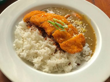 Buharda pilav ve zengin sosla servis edilen körili tavuk. Rahatlatıcı yemekler, Asya mutfağı, restoran menüsü ve öğle yemeği için ideal..