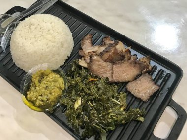 Izgara et, buğulanmış pirinç ve siyah tepside sebzelerle servis edilir. Öğle yemeği menüsü, dengeli yemek konsepti, restoran sunumu, ev yapımı yemekler ve günlük yemek fotoğrafçılığı için ideal..