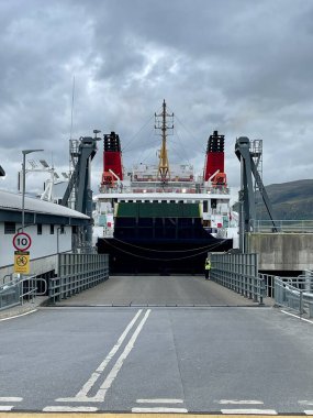 Büyük araba ve yolcu feribotu liman rampasına yanaştı bulutlu bir günde yüklemeye hazır.