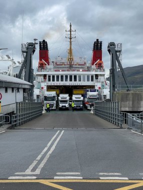 İskoç rıhtımında birden fazla kargo kamyonu yüklenen feribottan büyük bir dönüş.