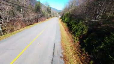 Gün batımında bir dağ yolunun FPV drone videosu.