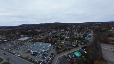 FPV insansız hava aracı bulutlu gökyüzünün altında ıslak şehir yolunda uçuyor.