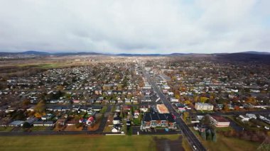 FPV insansız hava aracı yağmurdan önce şehirden kırsala geçiş gösteriyor, sinematik altın ışık