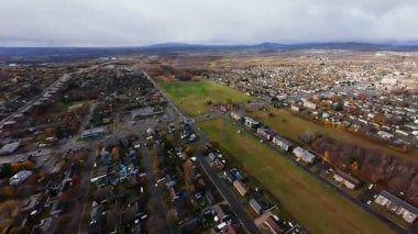 FPV insansız hava aracı yağmur yağmadan önce yol ve tarlalarda güneş ışığı yansımalarını gösteriyor.