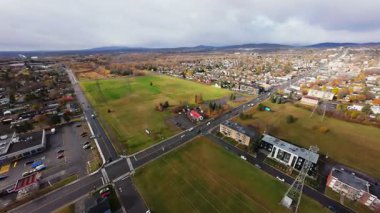 FPV insansız hava aracı kırsal ve şehir üzerinde uçuyor fırtınadan önce ufuk çizgisi, bulutlarda güneş ışığı