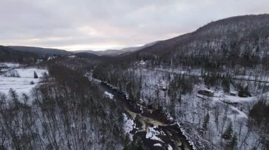 Donmuş bir vadi zemininin üzerinde, merkezden akan dar bir dereyle pürüzsüz bir uçuş..