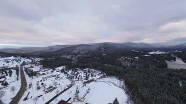 Dar, karlı bir vadinin üzerinde, dağ yamaçları arasında akan parlak bir nehir....