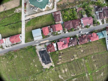 Sungai Penuh, Jambi, Endonezya 'daki tropikal ormanlarla çevrili yamaç manzarası. Highland bölgesinde teraslı arazi kullanımı, yeşil bitki örtüsü ve sürdürülebilir tarım gösteriliyor.