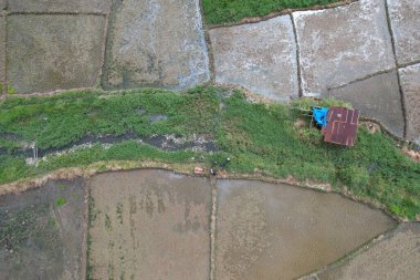 Sungai Penuh, Jambi, Endonezya 'daki kırsal yerleşim ve pirinç tarlalarının havadan görünüşü. Kentsel yayılmayı, tarım arazisi dönüşümünü ve tarım ve konut alanları arasındaki karışık kullanımlı manzarayı gösteriyor.