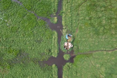 Sungai Penuh, Jambi, Endonezya 'daki kırsal yerleşim ve pirinç tarlalarının havadan görünüşü. Kentsel yayılmayı, tarım arazisi dönüşümünü ve tarım ve konut alanları arasındaki karışık kullanımlı manzarayı gösteriyor.