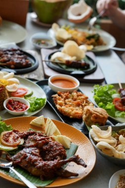 Geleneksel Endonezya yemekleri yerel bir restoranda ızgara tavuk, sambal, kızarmış pirinç, satay, taze sebze ve çıtır aperatiflerle servis edilir. Otantik Asya mutfağı yemek sahnesi.