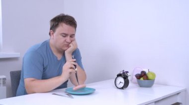 Depresyondaki adamda hiç açlık yok ya da kasten yemek yemeyi reddediyor. Diyet yapan şişman genç adam, masada oturuyor ve tatsız yemekler yemek istemiyor, ne yazık ki bıçakla sosis topluyor.
