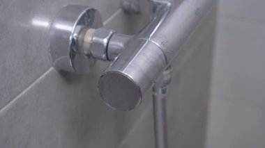 Biri ya da tesisatçı musluğu açıp işlevini kontrol eder ya da duş almak için suyu açar. Kapatın. Evdeki su tesisatının tamiri ve yenilenmesi.