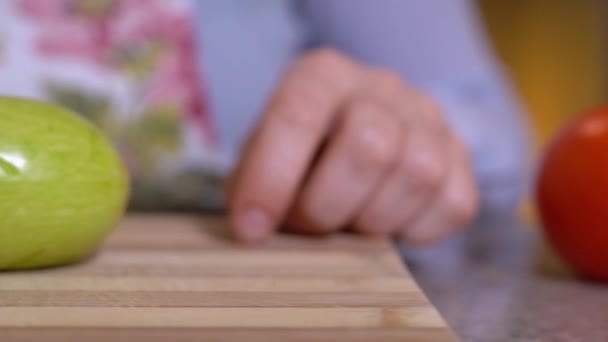 Los humanos cortan verduras frescas para preparar platos vegetarianos, patéticamente deslizan calabacín cortado de la tabla de cortar con cuchillo, de cerca, en cámara lenta. Mostrar publicidad cocinero o utensilios de cocina. — Vídeo de stock