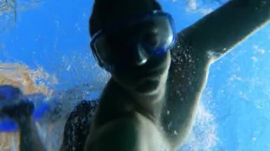 Şnorkel maskeli genç adam ilginç batık nesneler aramak ya da çeşitli deniz yaşamlarını keşfetmek için denize dalıyor, yüzeye geri dönüyor, aksiyon kamerasında sualtı çekimleri yapıyor.