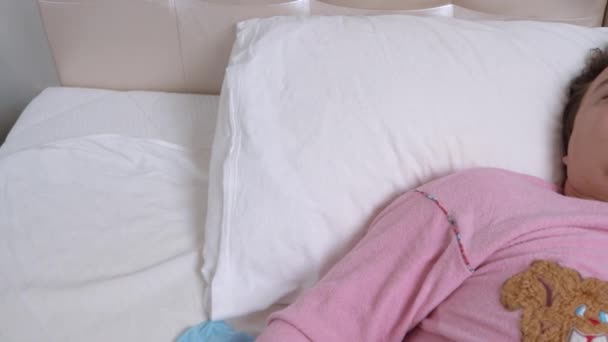 El joven en pijama rosa está profundamente dormido con la boca abierta debido a problemas respiratorios. Divertido perro salchicha en casa camiseta durmiendo en la almohada al lado del propietario — Vídeo de stock