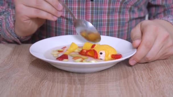 Gummi leksak kyckling med skrämd ansikte skära i bitar placerades i grönsakssoppa för person, närbild. Köttätare spelar spratt på vegetarisk vän — Stockvideo