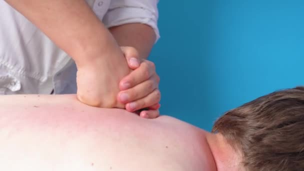 Professionell kiropraktor knackar energipunkter på ryggen med knytnävarna samtidigt som terapeutisk massage till patienten, böjande trötta muskler, närbild. Avslappnande behandling och rehabilitering — Stockvideo