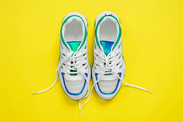 Top view of beautiful white stylish sneakers on a bright trendy yellow background — Stock Photo, Image