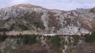 Dar bir otoyolda Heightview 'den İHA ile ateş etmek. Sonbaharda seyrek orman ve kuru otlarla kaplı dağların güzel manzarası..