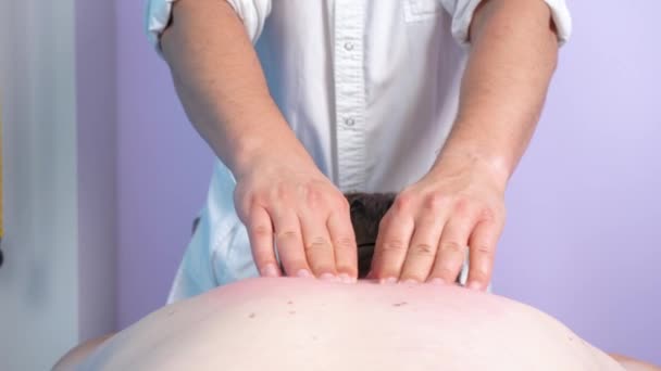 Osteopathic physician kneads thoracic and cervical spine with his palms and fingers while making therapeutic recovery massage to patient in Spa or clinic. Relaxing treatment and rehabilitation — Stock Video