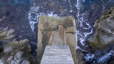 Denizde kayaların ve kayalıkların üzerinde fırtına veya kötü hava koşullarında güçlü dalgalar vuruyor. Yavaşça geliyor, açık havada.