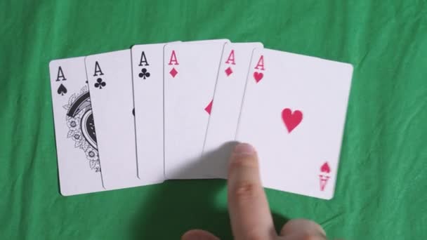 Manos humanas, contando cartas de juego en la mesa de póquer verde, con el doble de ases similares. Concepto de fraude o engaño — Vídeo de stock