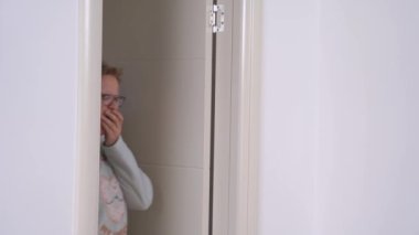 Uykulu tombul adam ve kadın ışık odasına doğru esneyerek geliyorlar.