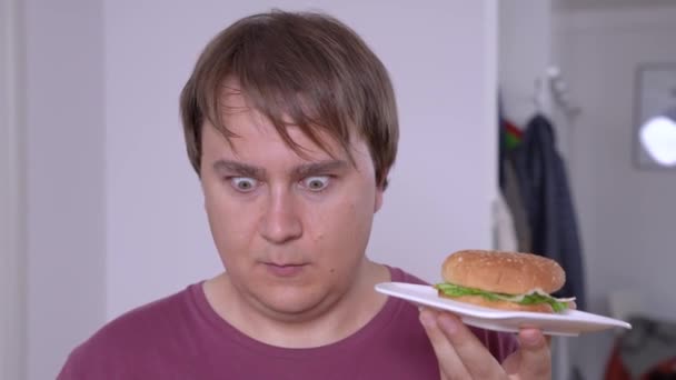 Jeune homme allait manger un délicieux hamburger pour le déjeuner, mais se souvenait de son grand poids et en état de choc couru pour une alimentation saine pour commencer à perdre du poids — Video