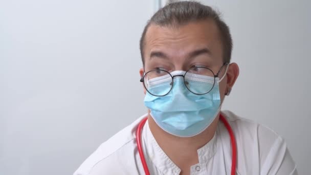 Médico chocado com óculos e ondas máscara mão adeus — Vídeo de Stock