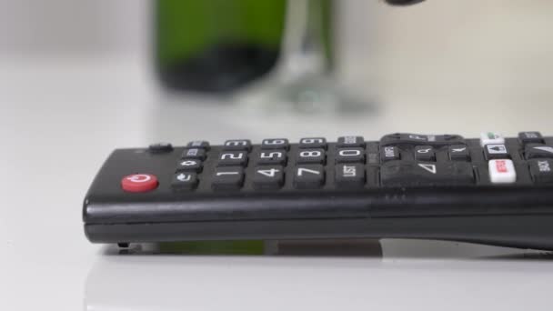 Paw of dog touches remote control buttons lying on table, close up, blurred background. Mischievous pet makes mess of house left alone at home — Stock Video