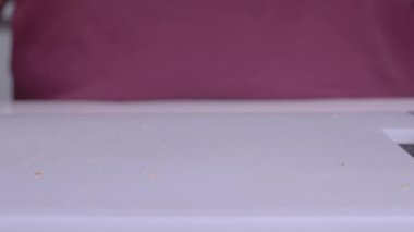 Adam abur cubur pişirmek için sandviçe buğday ekmeği atıyor.