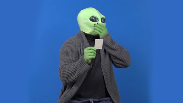 Groene alien kijkt naar het beeld en begint te hoesten op chromakey — Stockvideo