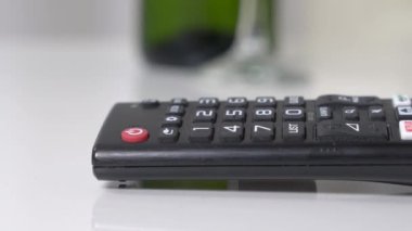 Dachshund köpek yavrusu TV 'yi açmak için uzaktan kumandaya basıyor