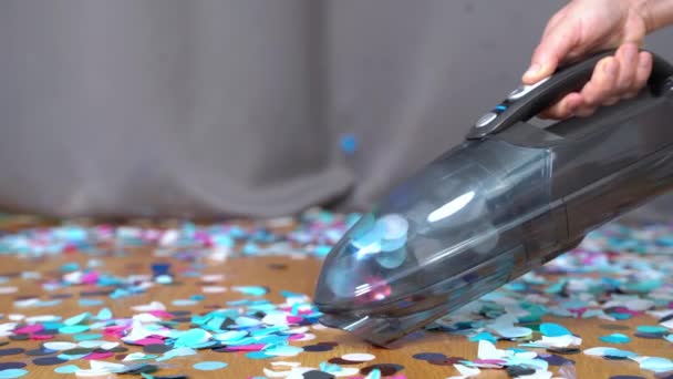 Orang membersihkan lantai confetti dengan vacuum cleaner portabel genggam setelah pesta, close up, side view. Layanan outsourcing untuk pembersihan profesional tempat — Stok Video