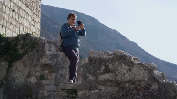 Homme dodu touriste prend des photos sur le mur de la vieille forteresse — Video