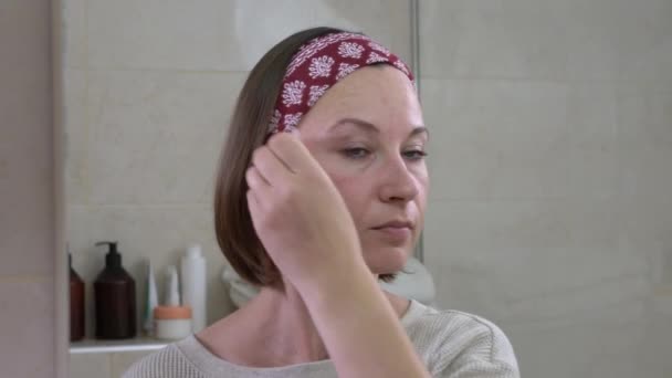 Mujer de mediana edad masajea la cara con rodillo de cuarzo especial — Vídeos de Stock