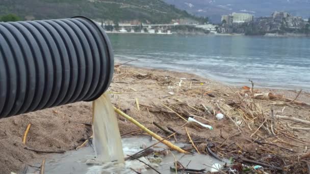 Smutsigt vatten rinner ner från plaströr på stranden — Stockvideo