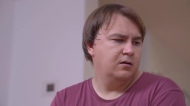 Düşünceli, iri yarı bir adam odada önemli kararlar verir.