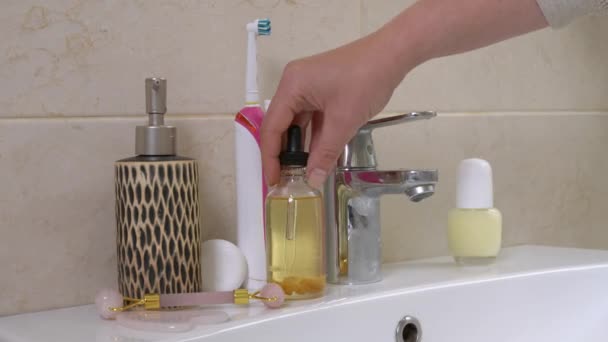 Woman chooses cosmetic product to use during morning or evening beauty treatments. Person takes pipette and fills it with natural oil-serum to moisturize and rejuvenate skin — Stock Video