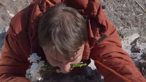 Silný chlap se sedmikráskami v zubech jde dolů z příkrého útesu — Stock video