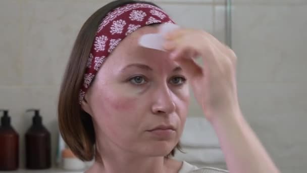 Maturo signora utilizza quarzo rosa gua sha sciarpa sulla fronte — Video Stock
