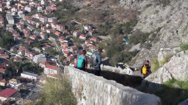 Menschen gehen am Frühlingstag die Treppe entlang auf der Festung Kotor — Stockvideo