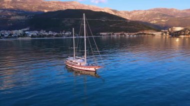 Açık gök mavisi deniz suyunda güneş ışığı yansıması ile yat