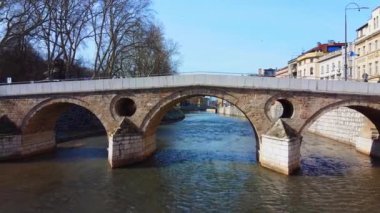 Nehirdeki tarihi taş köprü, temiz gökyüzünün altında.