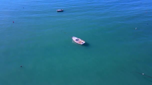 Small white moored motorboat on turquoise rippling sea water — Video Stock